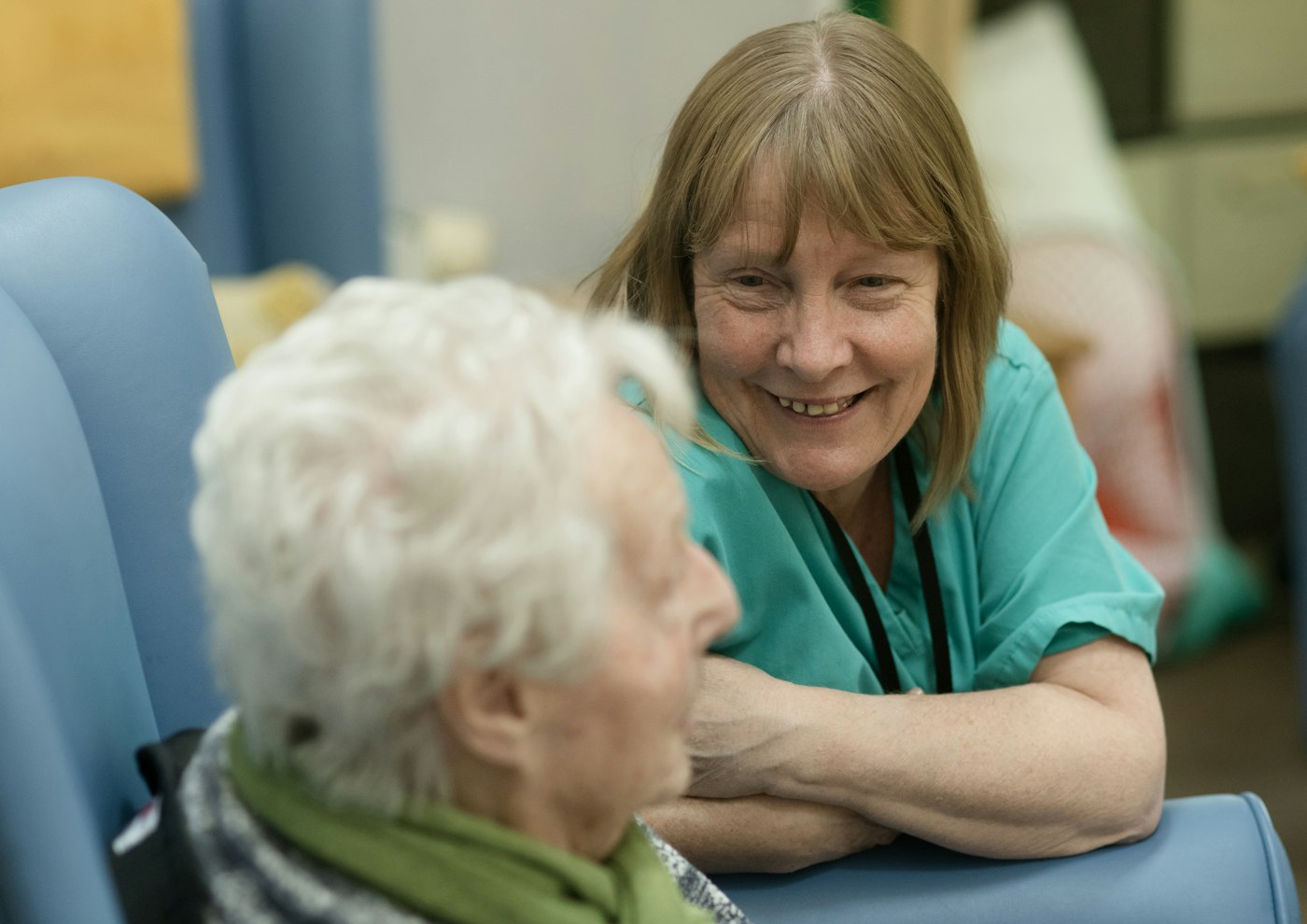 Caregiver smiling while talking to an elderly woman